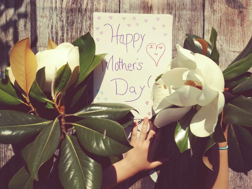 person near happy mothers day signage and plants