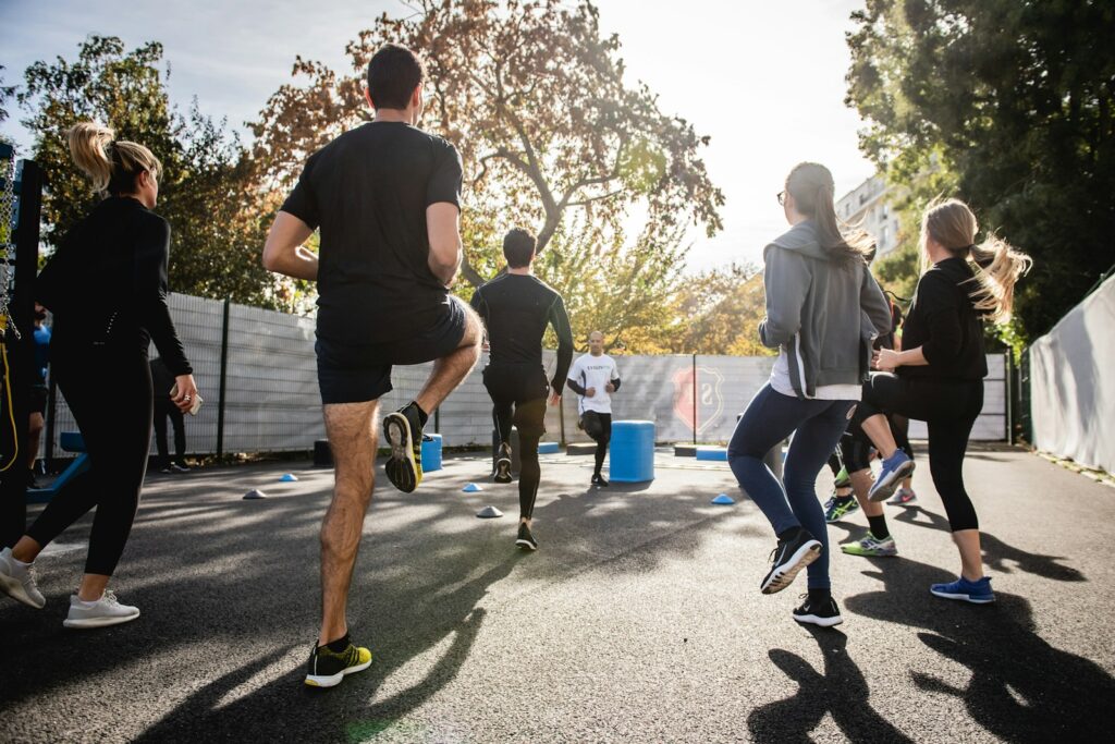 man in black t shirt and black shorts running on road during daytime